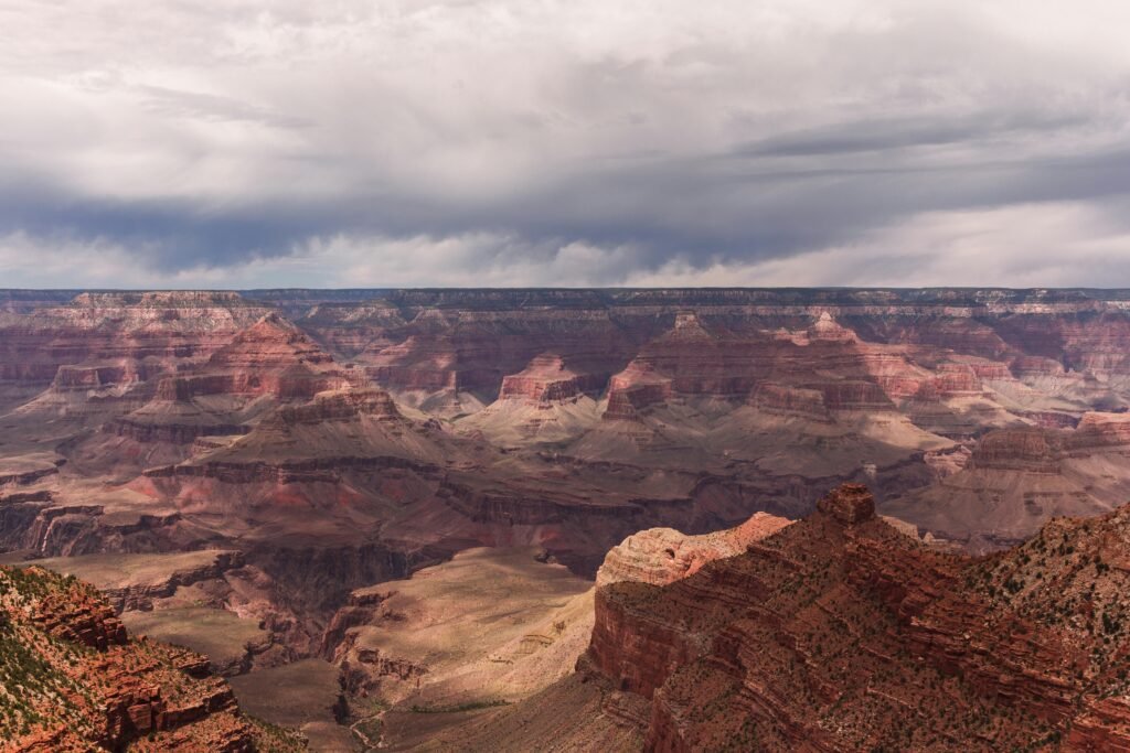 Stunning panoramic view of the Grand Canyon's majestic cliffs and valleys under dramatic skies.